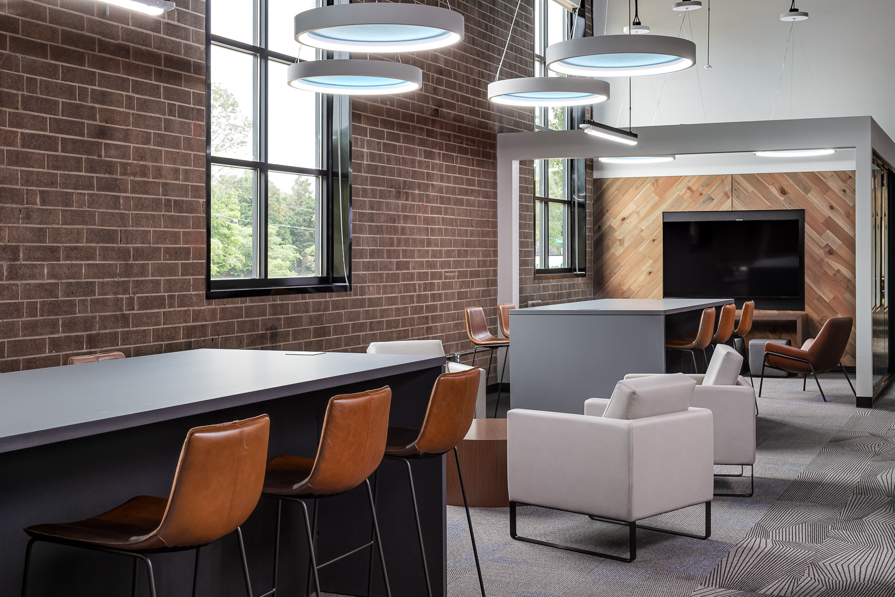 Commercial photography of a modern office showcasing its brick wall and chairs.