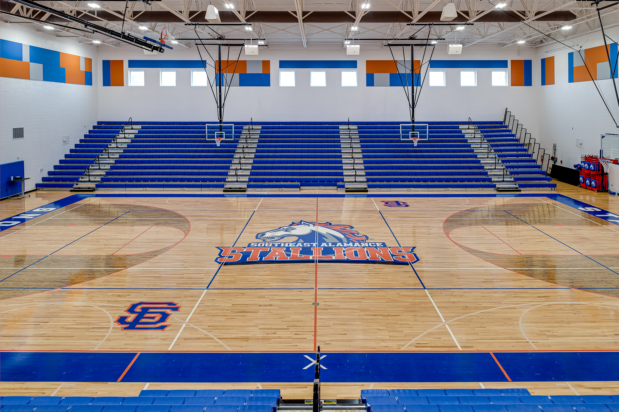 An interior design photographer captures a basketball court's blue and orange seats in North Carolina.