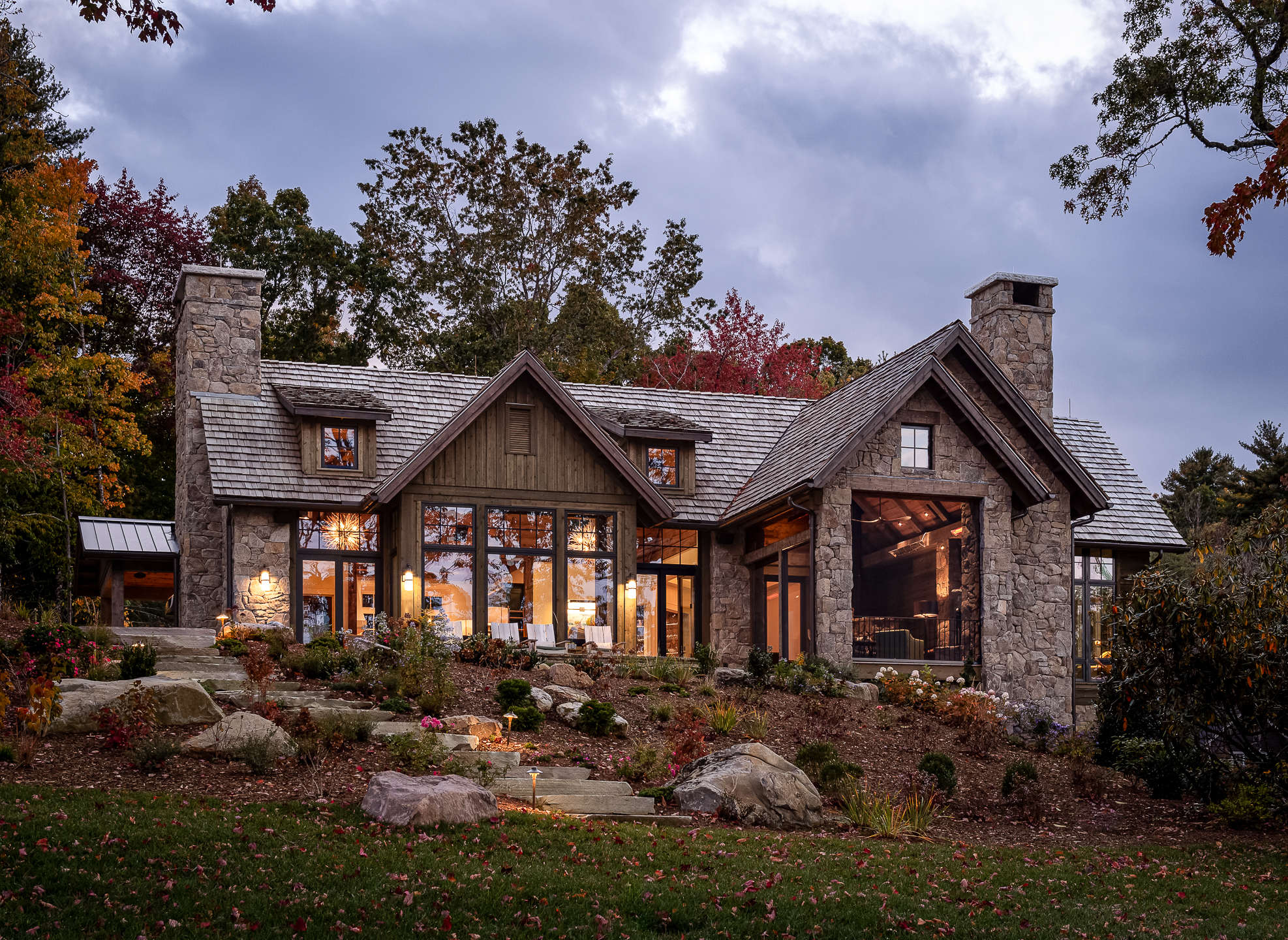 A stone home in the woods at dusk. captured by professional architectural photographer in Asheville, North Carolina
