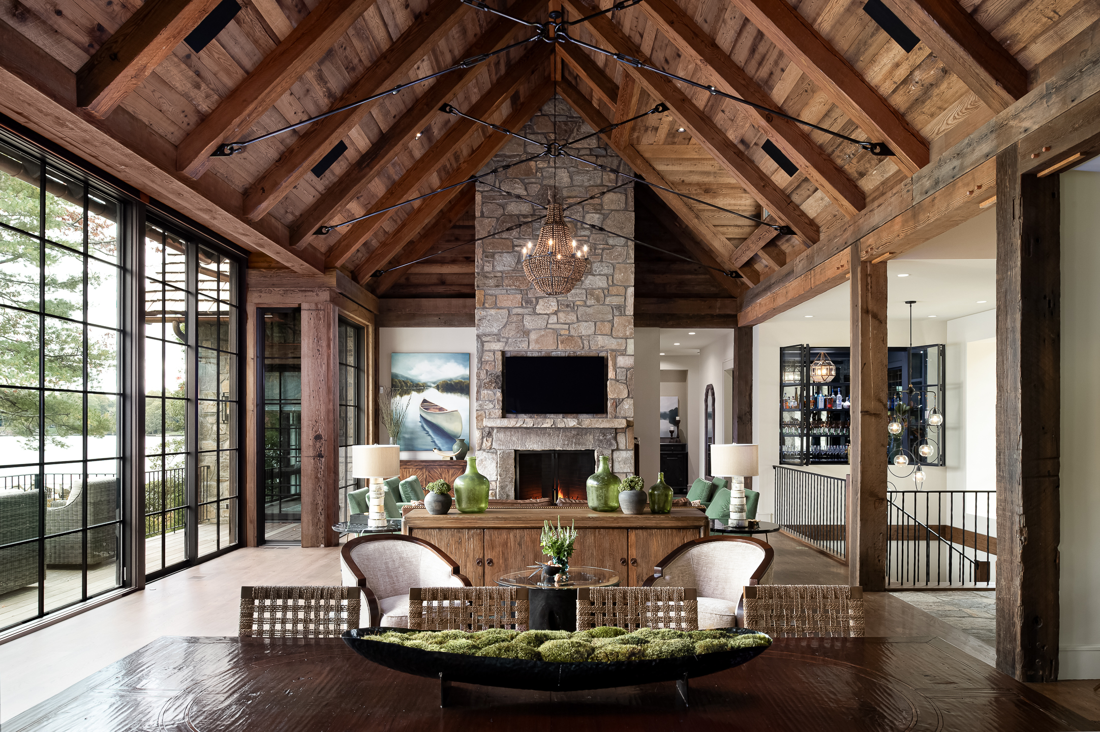 A large living room with wood beams and a fireplace. captured by professional architectural photographer Charlotte, North Carolina