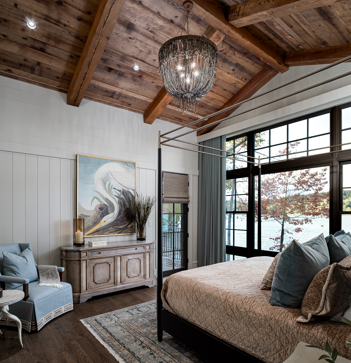 A bedroom with wood ceilings and a large bed. captured by interior design photographer in Brevard, North Carolina