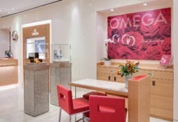 A commercial photographer captures the vibrant red chairs and wall of a store.