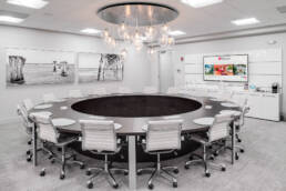 A commercial photography studio with a circular table and chairs for conferences.
