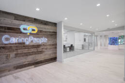 an office with a wooden wall and a sign that says caring people.