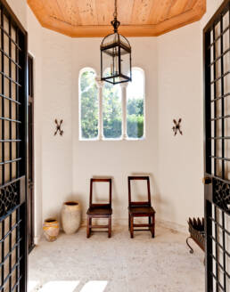 a hallway with two chairs and a lantern.