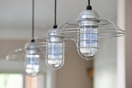 three light fixtures hanging from a ceiling in a kitchen.