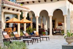 a patio with patio furniture and orange umbrellas.