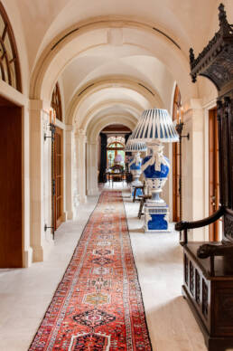 a hallway with a rug and lamps.
