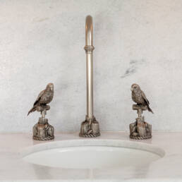 a sink with two bird statues on it.