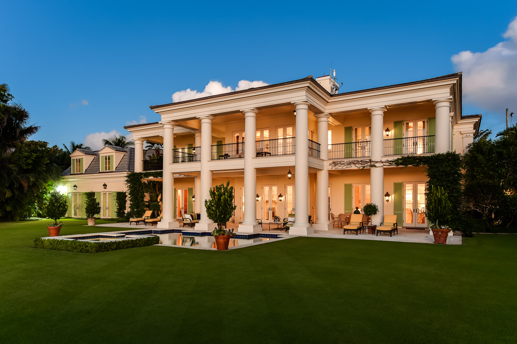 a large mansion in the middle of a lush green lawn.