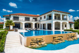 a large mansion with a pool and waterfall.