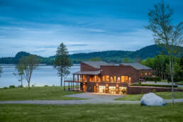 a large house with a lake in the background photographed by professional architectural photographer