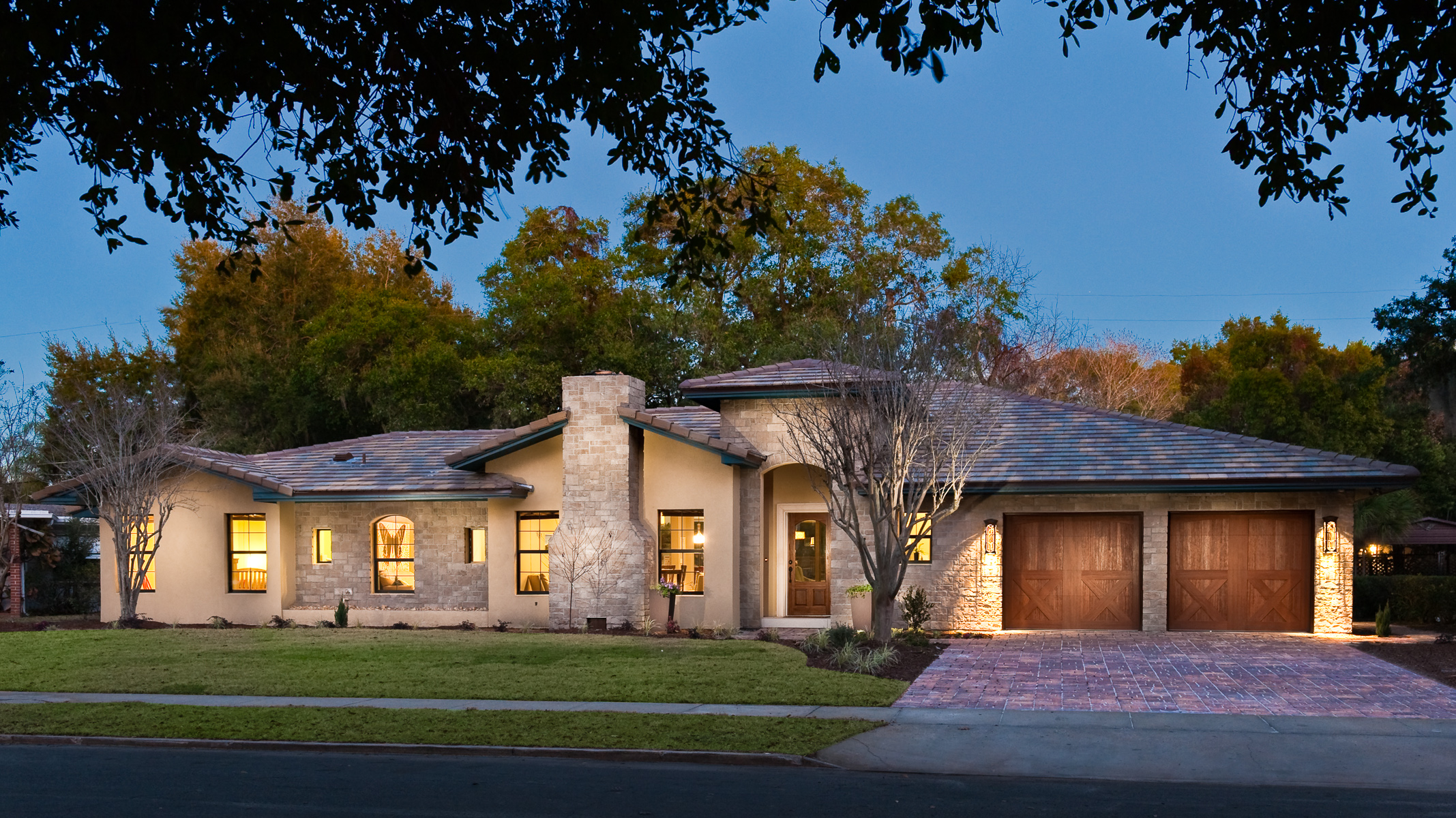 a home with a driveway and garage at dusk.