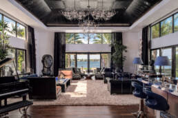a large living room with a piano and chandelier.