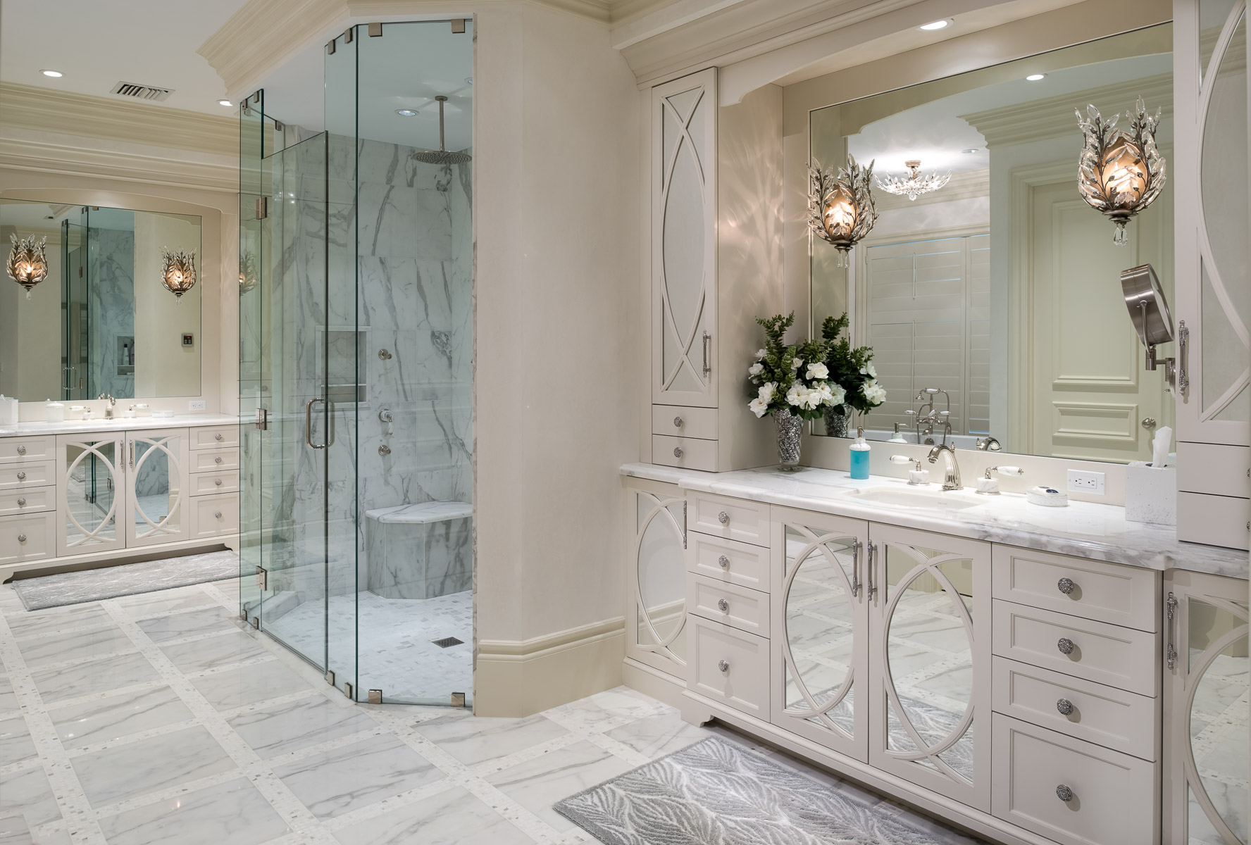a large bathroom with marble counter tops and a glass shower.