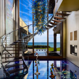 a spiral staircase in a house with a view of the ocean.