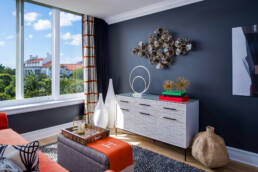a living room with blue walls and orange accents.