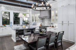 a white kitchen with a dining table and chairs.