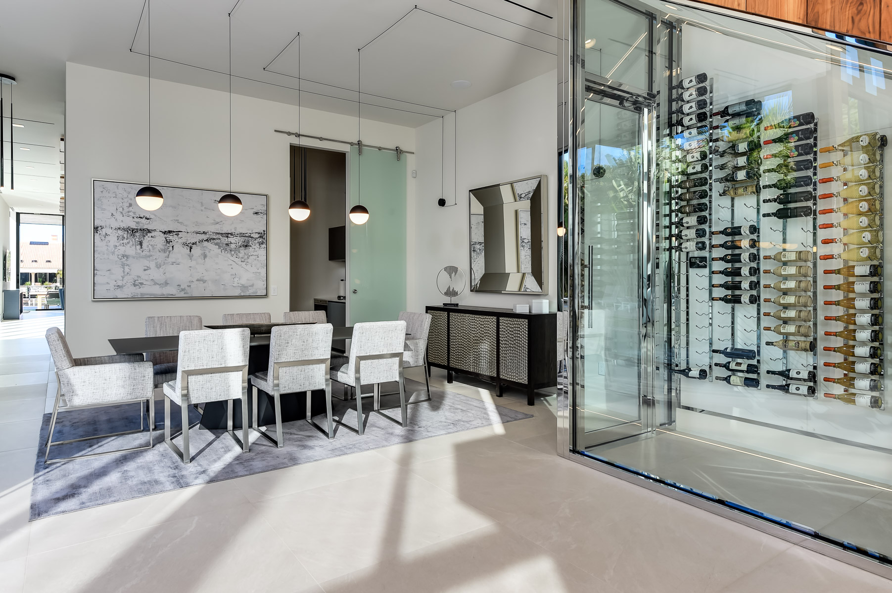 An interior design photographer captures a modern glass-walled wine cellar in a dining room.
