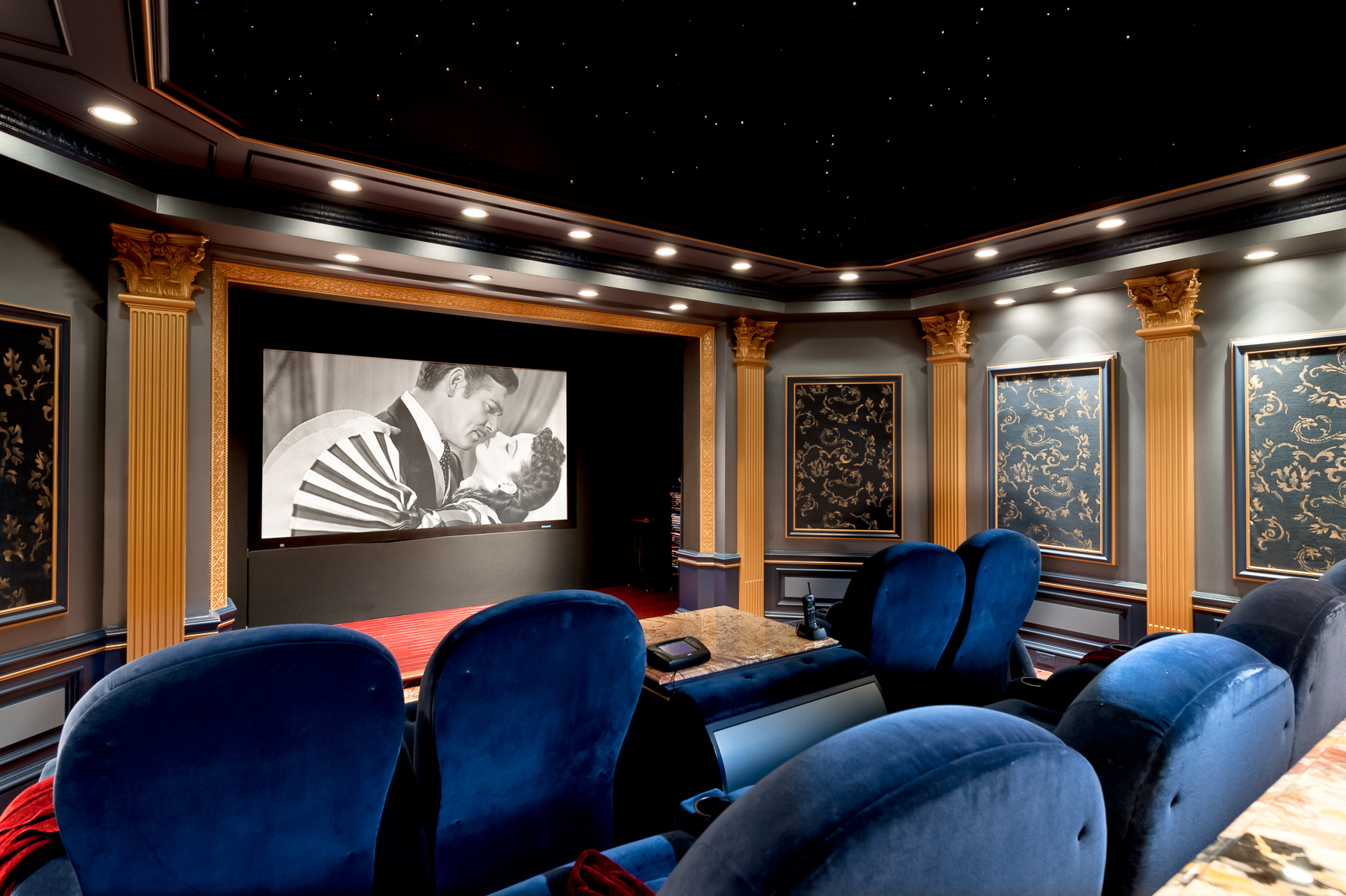 a home theater with blue chairs and a movie screen.