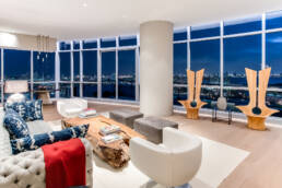 a living room with large windows overlooking the city.